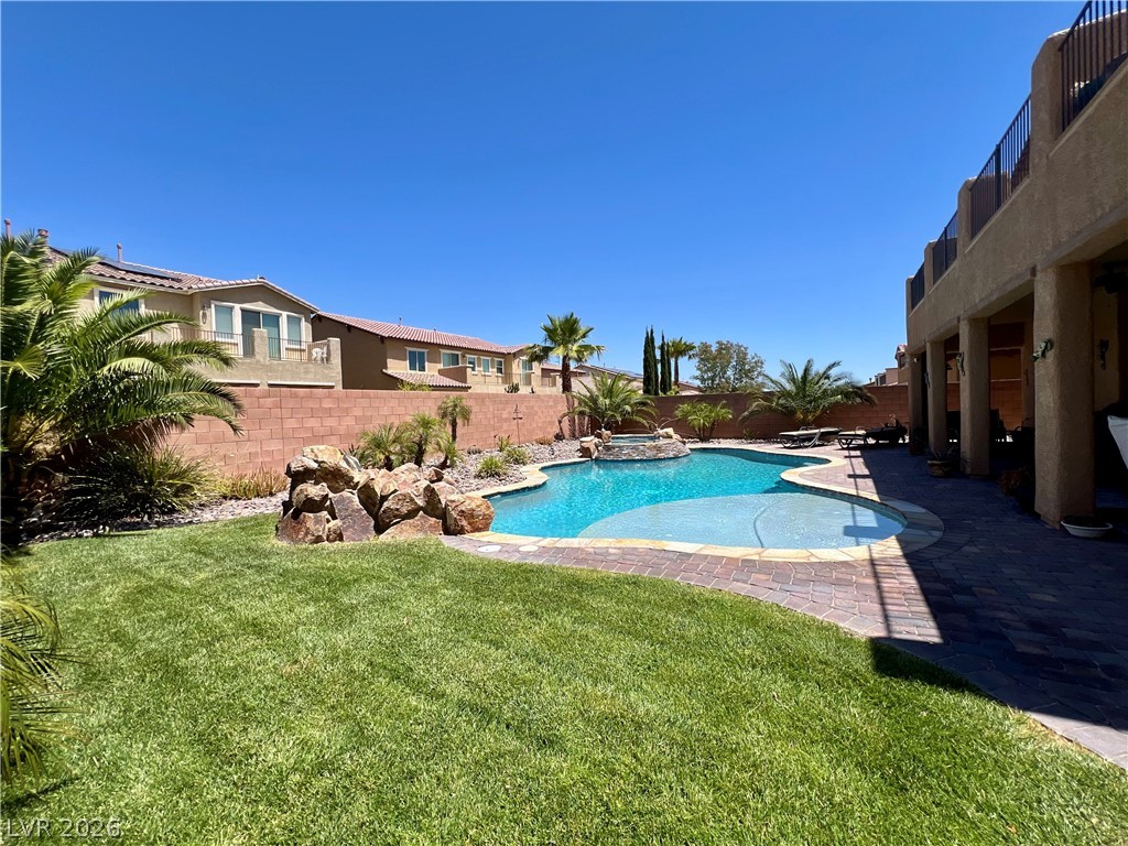 9724 University Ridge Avenue Las Vegas, NV 89149 - Photo 21 of 61 A private backyard oasis features a shimmering pool with rock accents, a spa, and abundant green space.