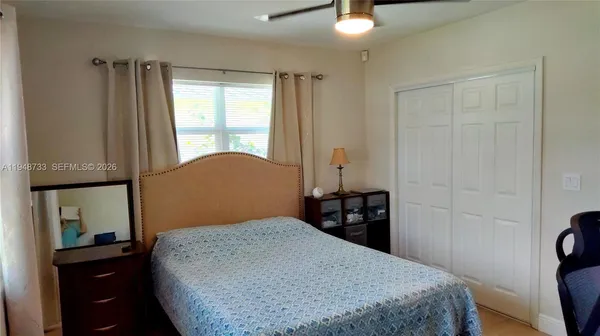 a bedroom with a bed and dresser with mirror