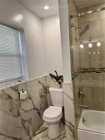 a bathroom with a toilet and a shower