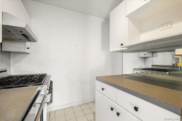 a kitchen with granite countertop a sink a stove and cabinets