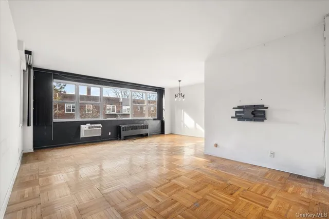 a view of an empty room with a fireplace and a window