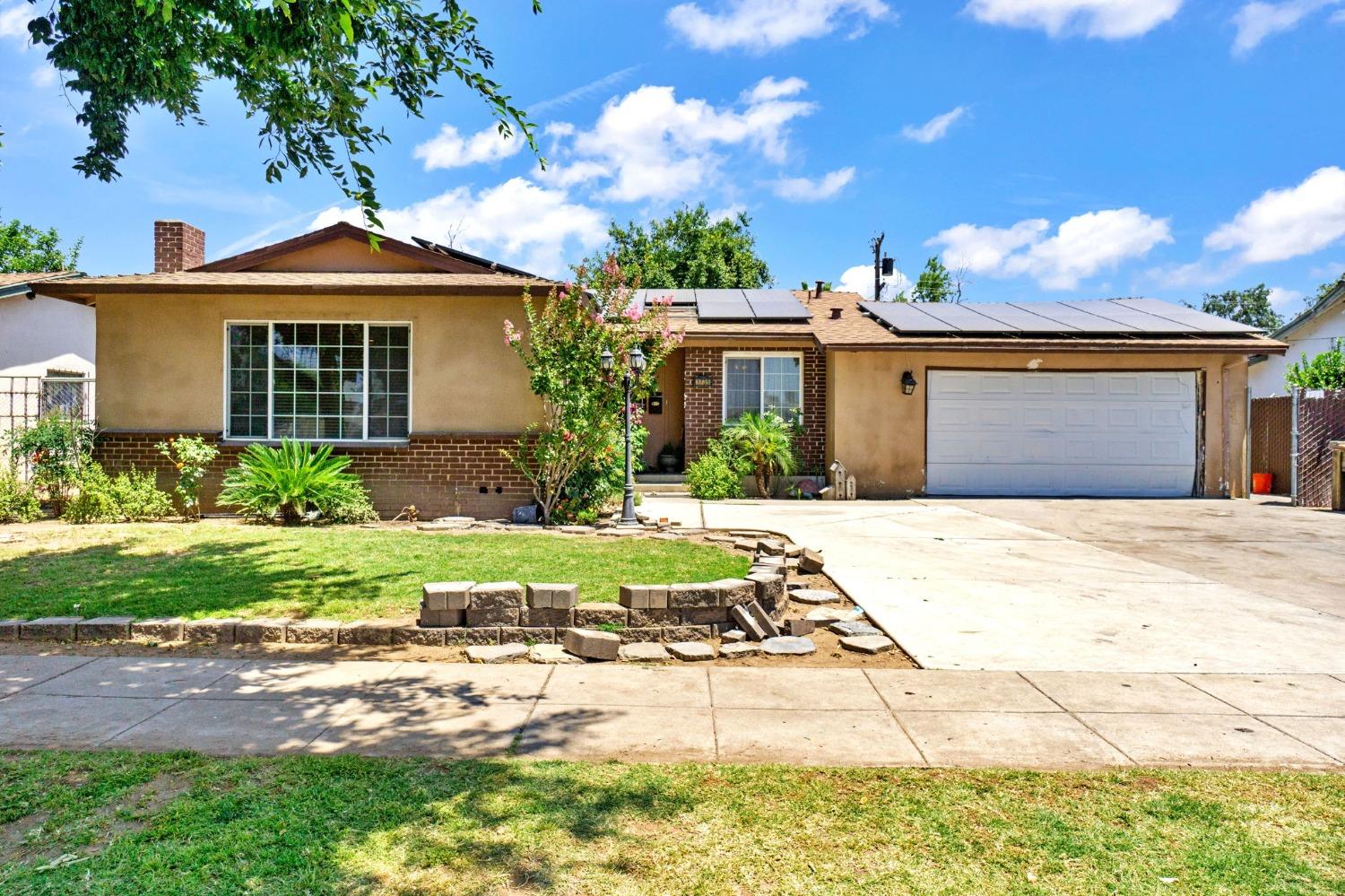1735 South Maple Avenue Fresno, CA 93702 - Photo 1 of 24 a front view of a house with garden