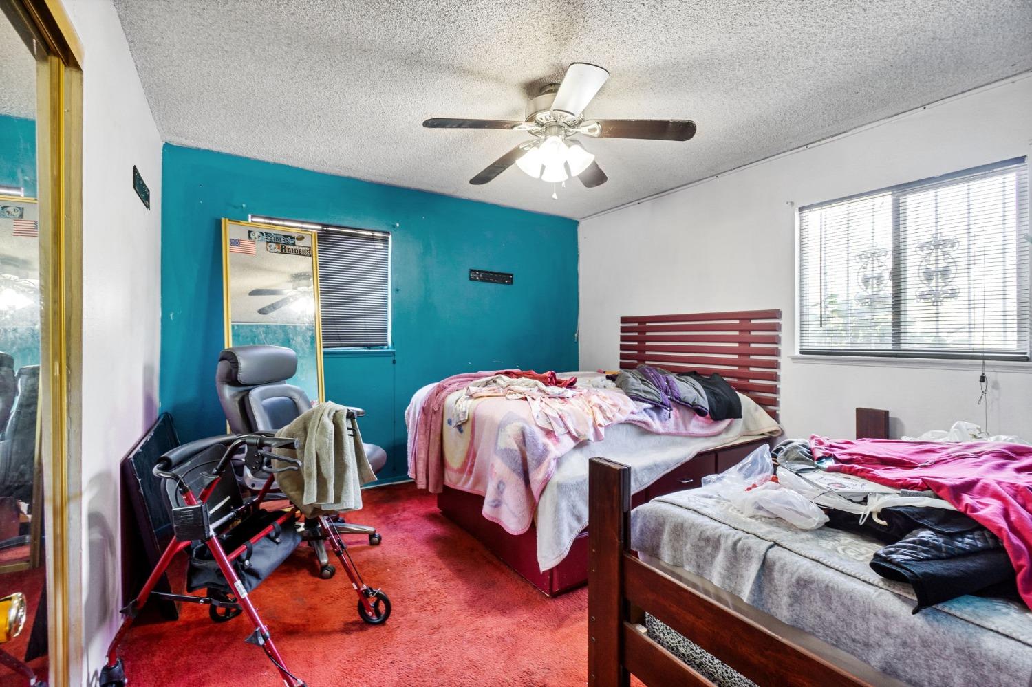 1735 South Maple Avenue Fresno, CA 93702 - Photo 12 of 24 a bedroom with two beds and a chandelier