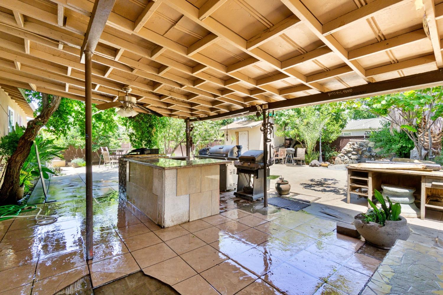 1735 South Maple Avenue Fresno, CA 93702 - Photo 16 of 24 a view of a patio with table and chairs potted plants with wooden floor and fence