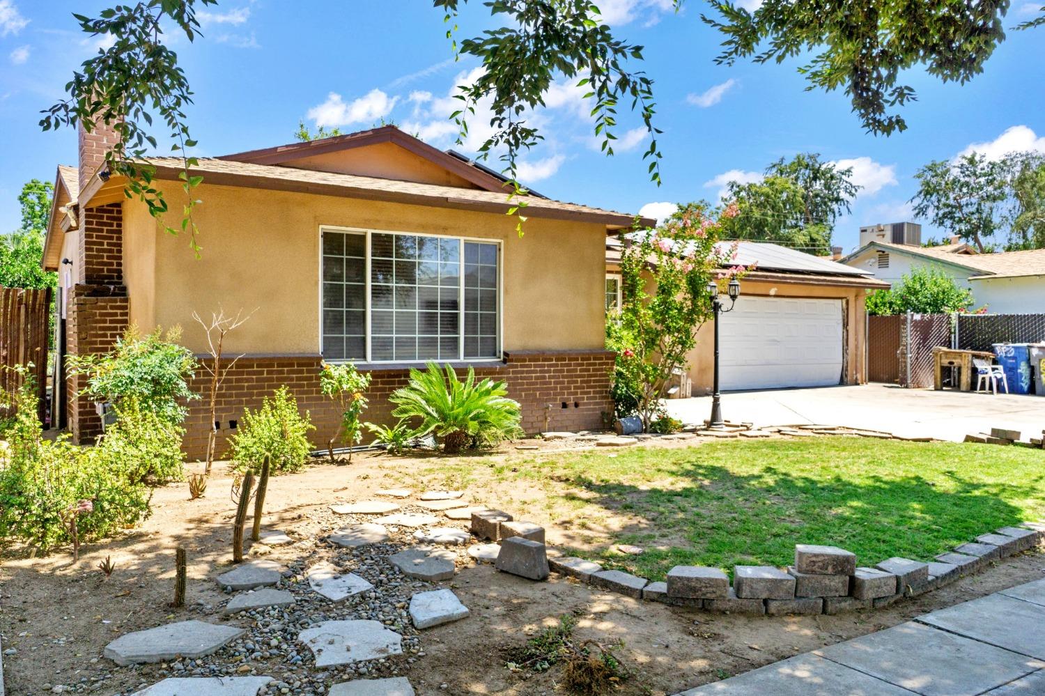 1735 South Maple Avenue Fresno, CA 93702 - Photo 2 of 24 a front view of a house with a yard and potted plants