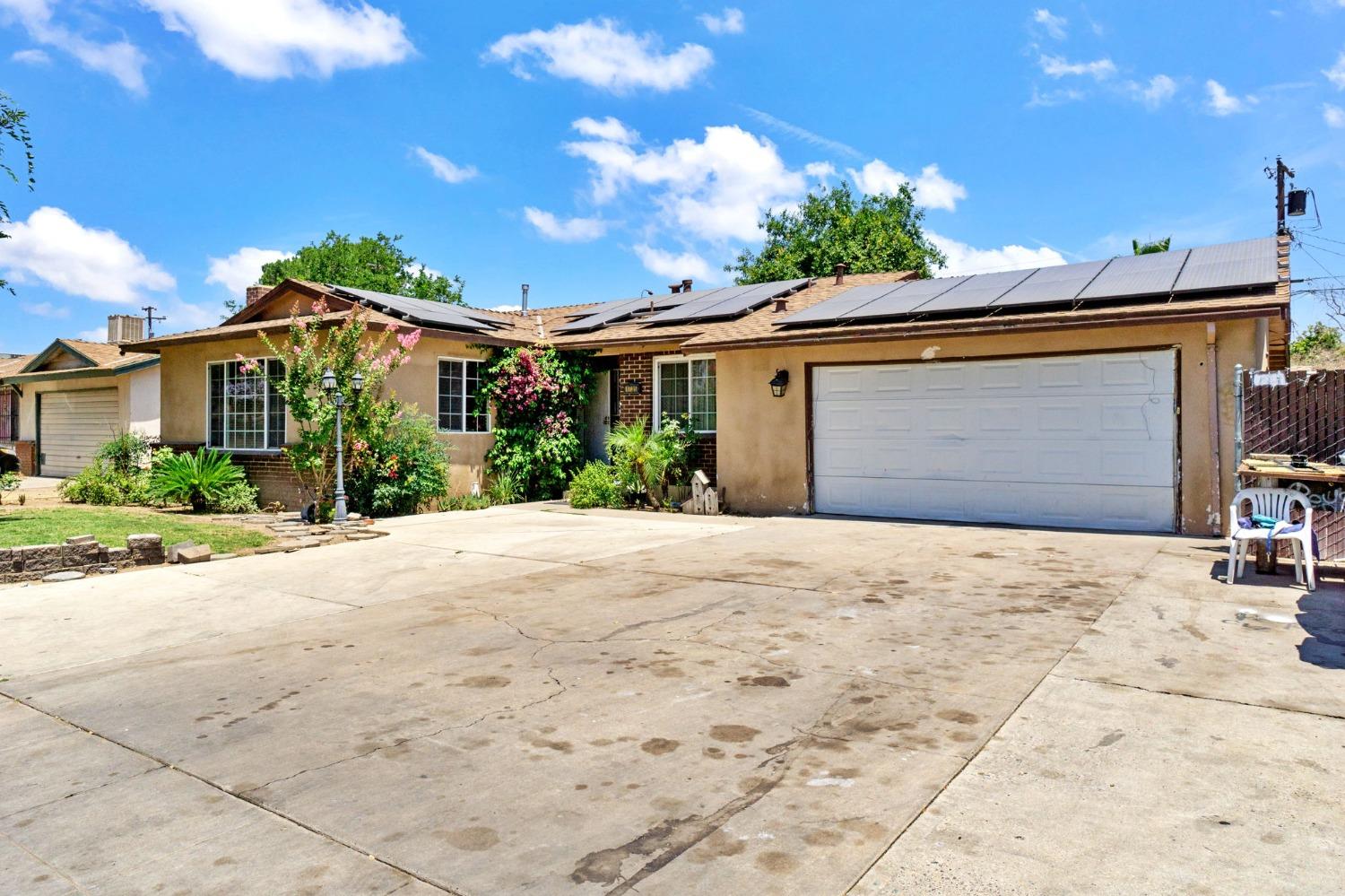 1735 South Maple Avenue Fresno, CA 93702 - Photo 3 of 24 a front view of a house with a yard and garage