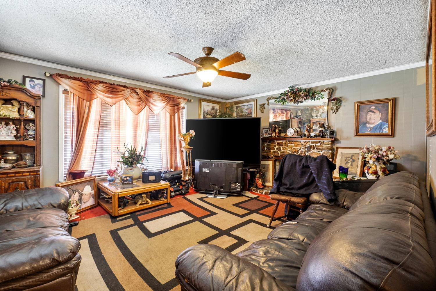 1735 South Maple Avenue Fresno, CA 93702 - Photo 5 of 24 a living room with furniture a flat screen tv and a floor to ceiling window