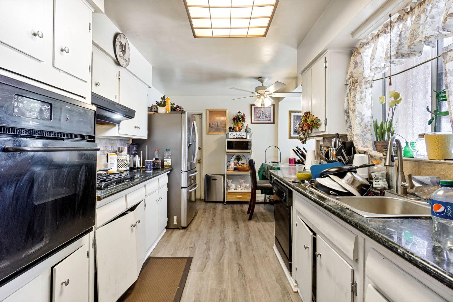 1735 South Maple Avenue Fresno, CA 93702 - Photo 8 of 24 a kitchen with stainless steel appliances granite countertop a sink and wooden cabinets