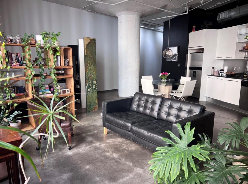 1122 Jackson Street, Unit 514 Dallas, TX 75202 - Photo 14 of 40 Open-concept living area featuring polished concrete flooring, exposed ceiling with visible ductwork, and an industrial-style column