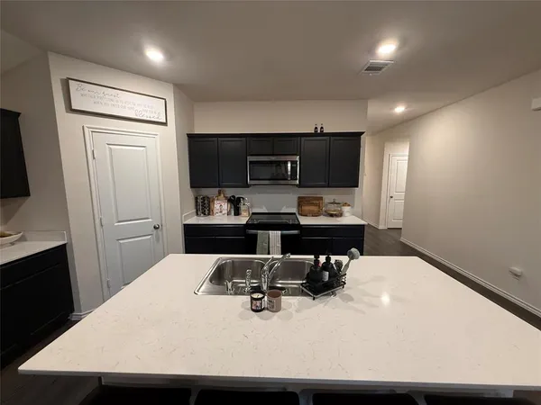a kitchen with stainless steel appliances kitchen island a refrigerator sink stove and oven