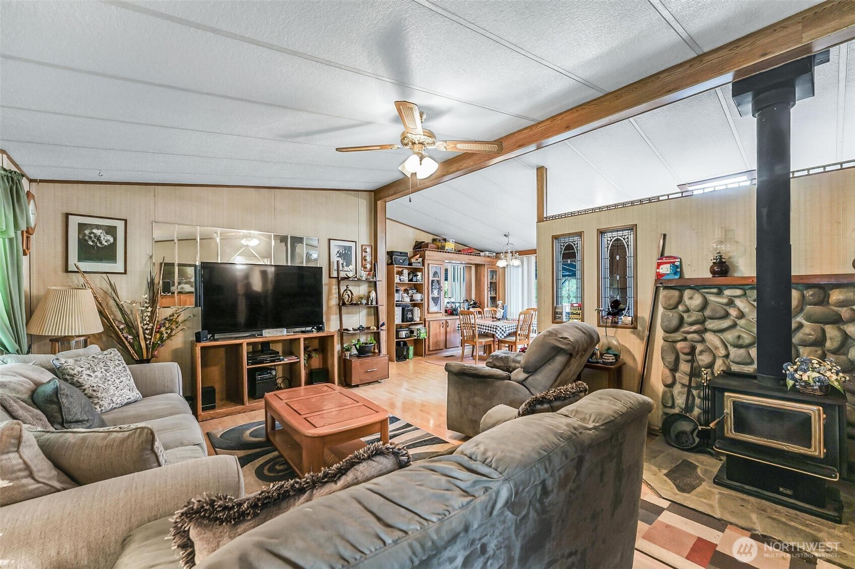 980 South Falcon Road Camano Island, WA 98282 - Photo 9 of 30 a living room with furniture a flat screen tv and a fireplace