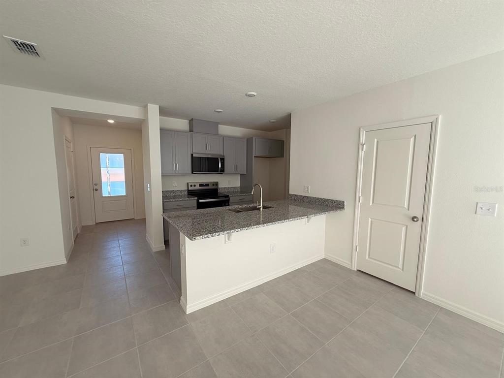 16607 Luminary Loop Clermont, FL 34714 - Photo 3 of 18 a view of kitchen with sink and microwave