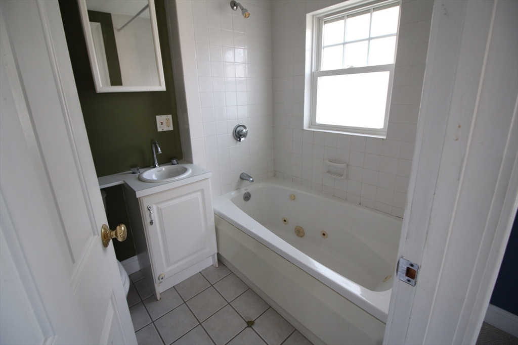 4 Wilson Street, Unit LEFT Billerica, MA 01862 - Photo 17 of 29 a bathroom with a bathtub a window and a shower