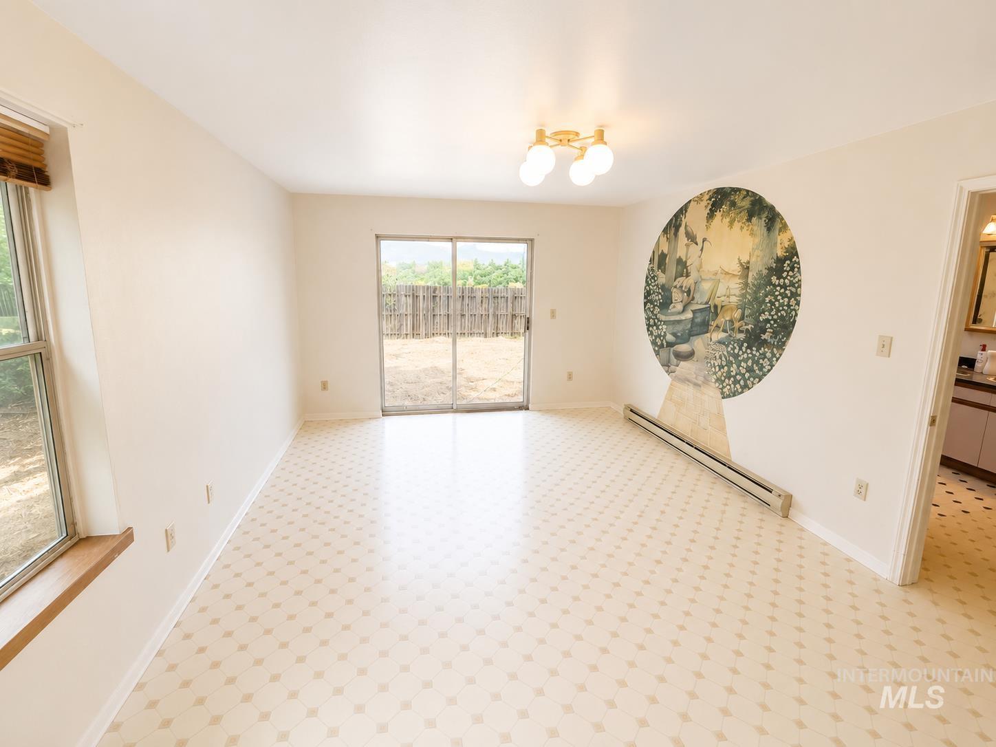 16434 Pride Lane Caldwell, ID 83607 - Photo 12 of 16 Spacious room featuring patterned flooring, white walls, and a large sliding glass door opening to the backyard