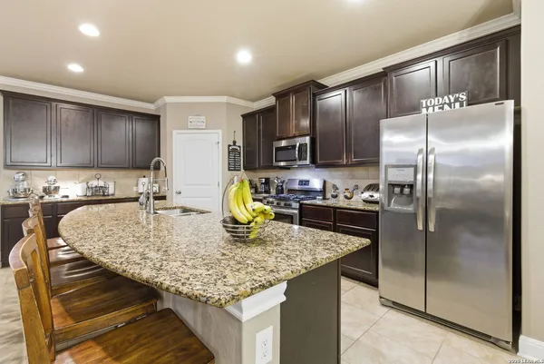 a kitchen with stainless steel appliances granite countertop a sink a stove and a refrigerator