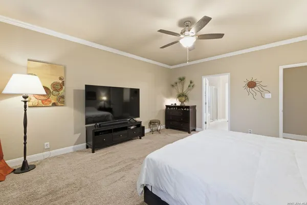 a bedroom with a bed and a flat tv screen on dresser