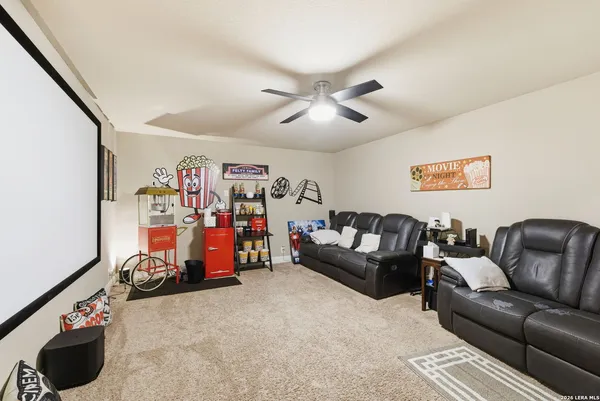 a living room with furniture a ceiling fan and a rug