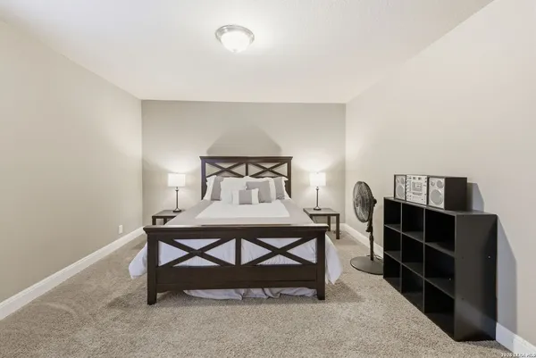a bedroom with a bed and a flat tv screen on a dresser
