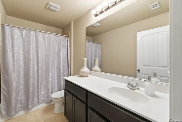 a spacious bedroom with a bed and a flat screen tv
