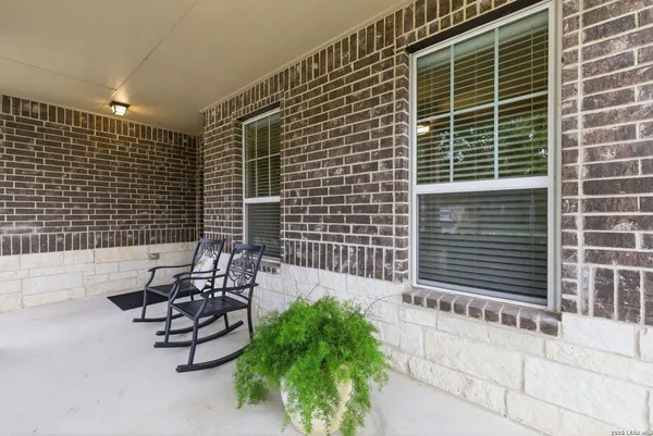a view of a chair and table in the back yard of the house