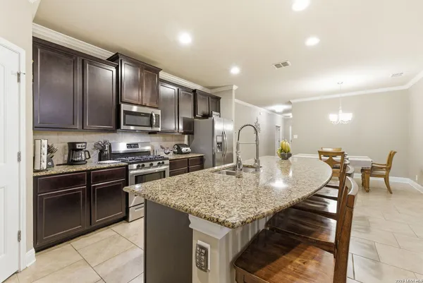 a kitchen with stainless steel appliances granite countertop a stove a sink a microwave and a refrigerator