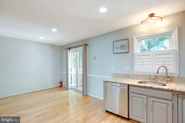 a kitchen with a sink cabinets and wooden floor