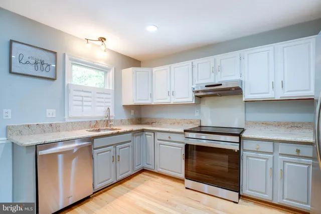 a kitchen with granite countertop cabinets stainless steel appliances and a sink