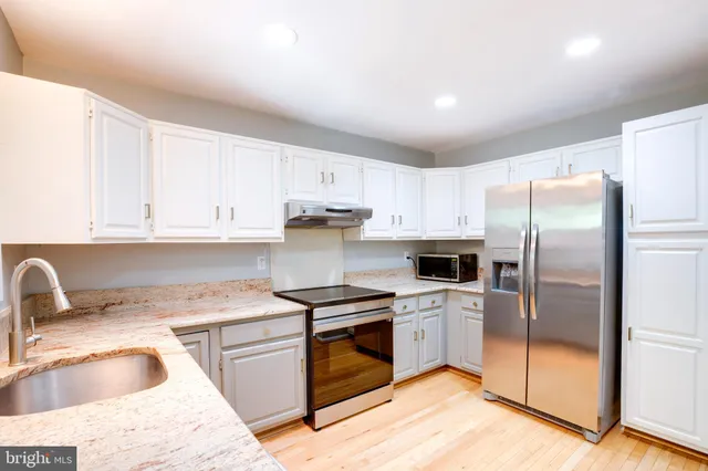 a kitchen with a sink a refrigerator and cabinets