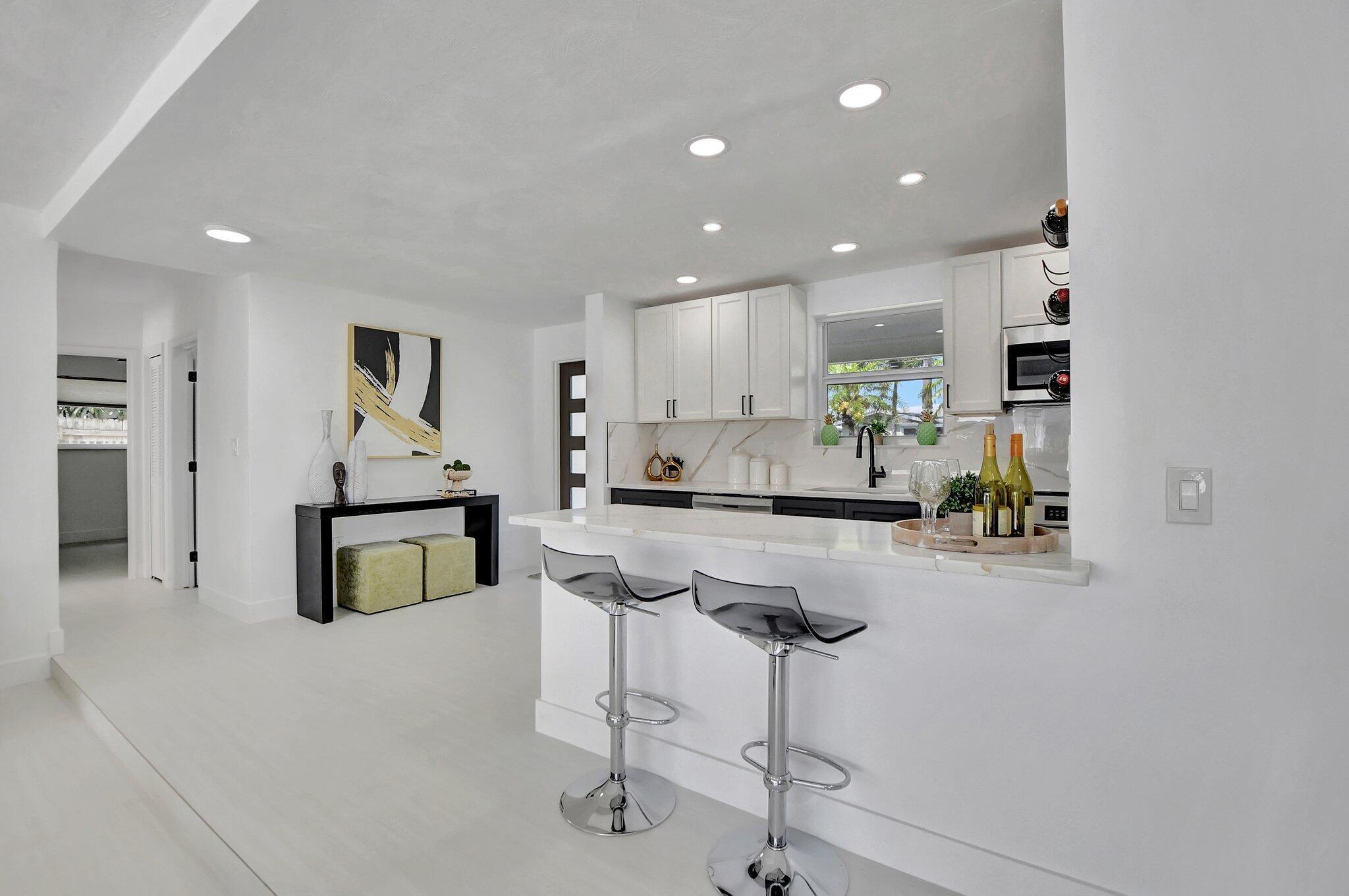 832 Southwest 10th Avenue Boca Raton, FL 33486 - Photo 10 of 57 a kitchen with white cabinets and chairs