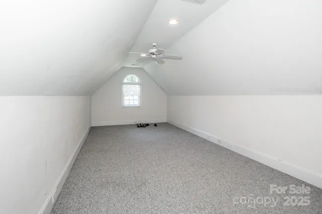 an empty room with a window and ceiling fan