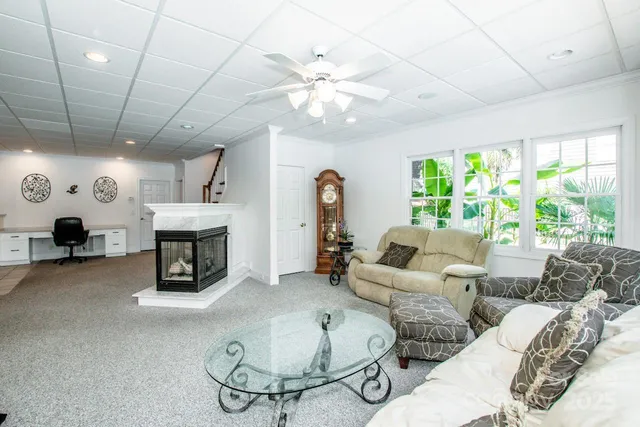 a living room with furniture a fireplace and a chandelier