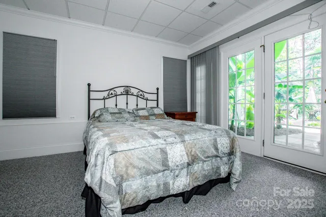 a bed sitting in a spacious bedroom next to a window