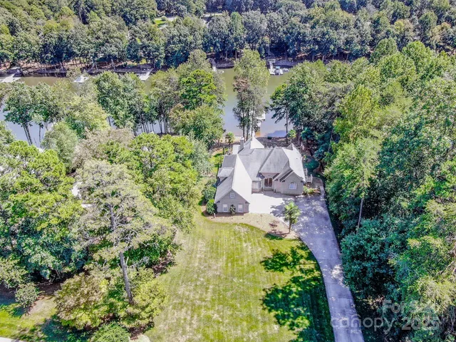 an aerial view of residential house with outdoor space and trees all around