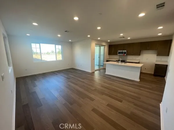 an open kitchen view with wooden floor and windows