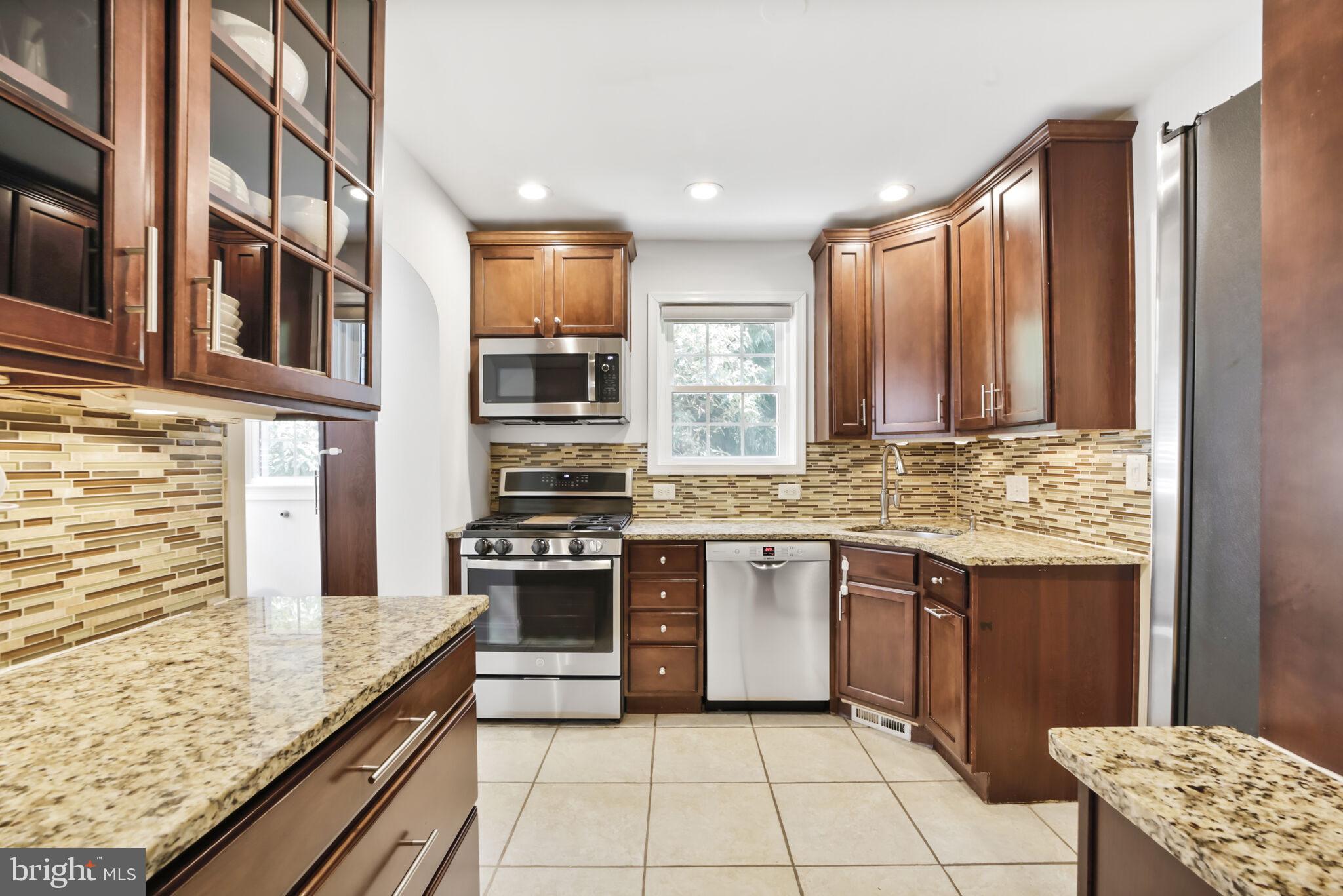 1512 Live Oak Drive Silver Spring, MD 20910 - Photo 12 of 34 a kitchen with stainless steel appliances granite countertop a stove a sink and a microwave