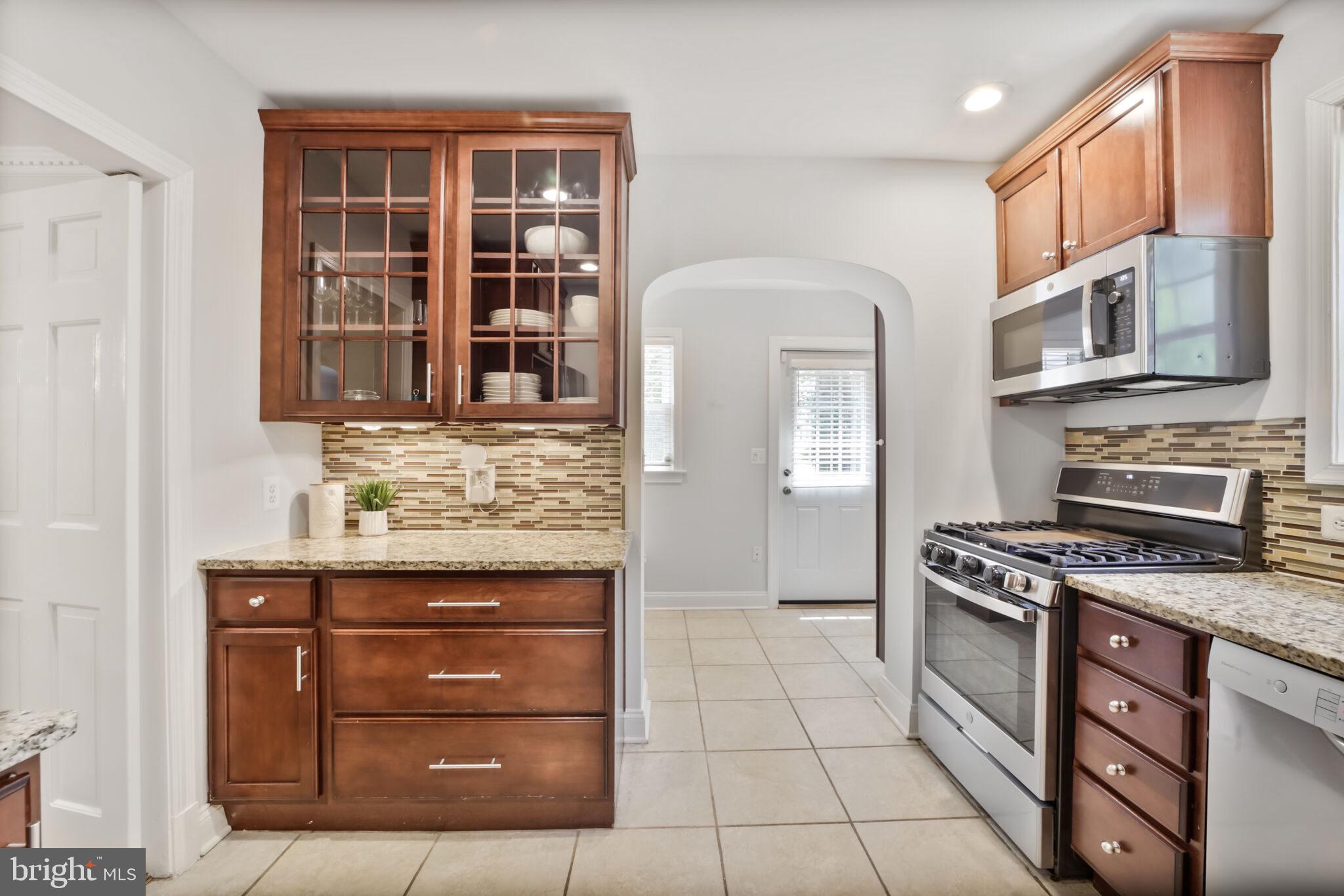 1512 Live Oak Drive Silver Spring, MD 20910 - Photo 13 of 34 a kitchen with stainless steel appliances granite countertop a stove and a refrigerator