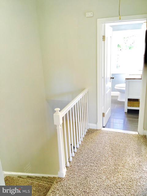 6023 Falkirk Road Baltimore, MD 21239 - Photo 12 of 20 a view of a hallway with wooden floor and a living room