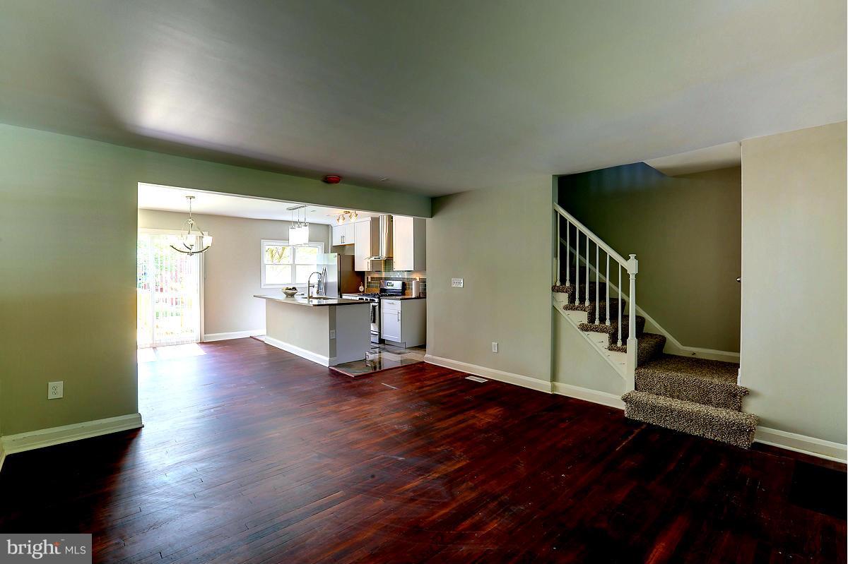 6023 Falkirk Road Baltimore, MD 21239 - Photo 4 of 20 a view of empty room with wooden floor and windows