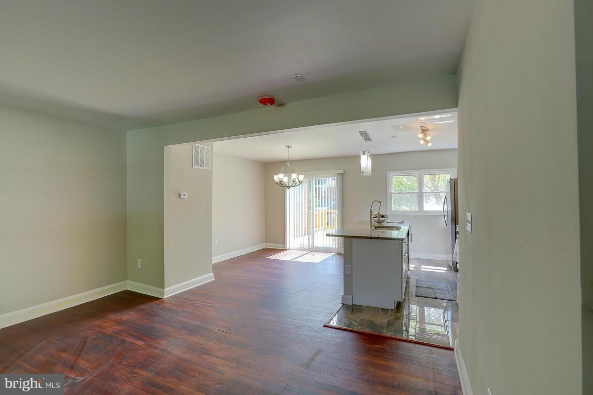 6023 Falkirk Road Baltimore, MD 21239 - Photo 5 of 20 a view of a big room with wooden floor and windows