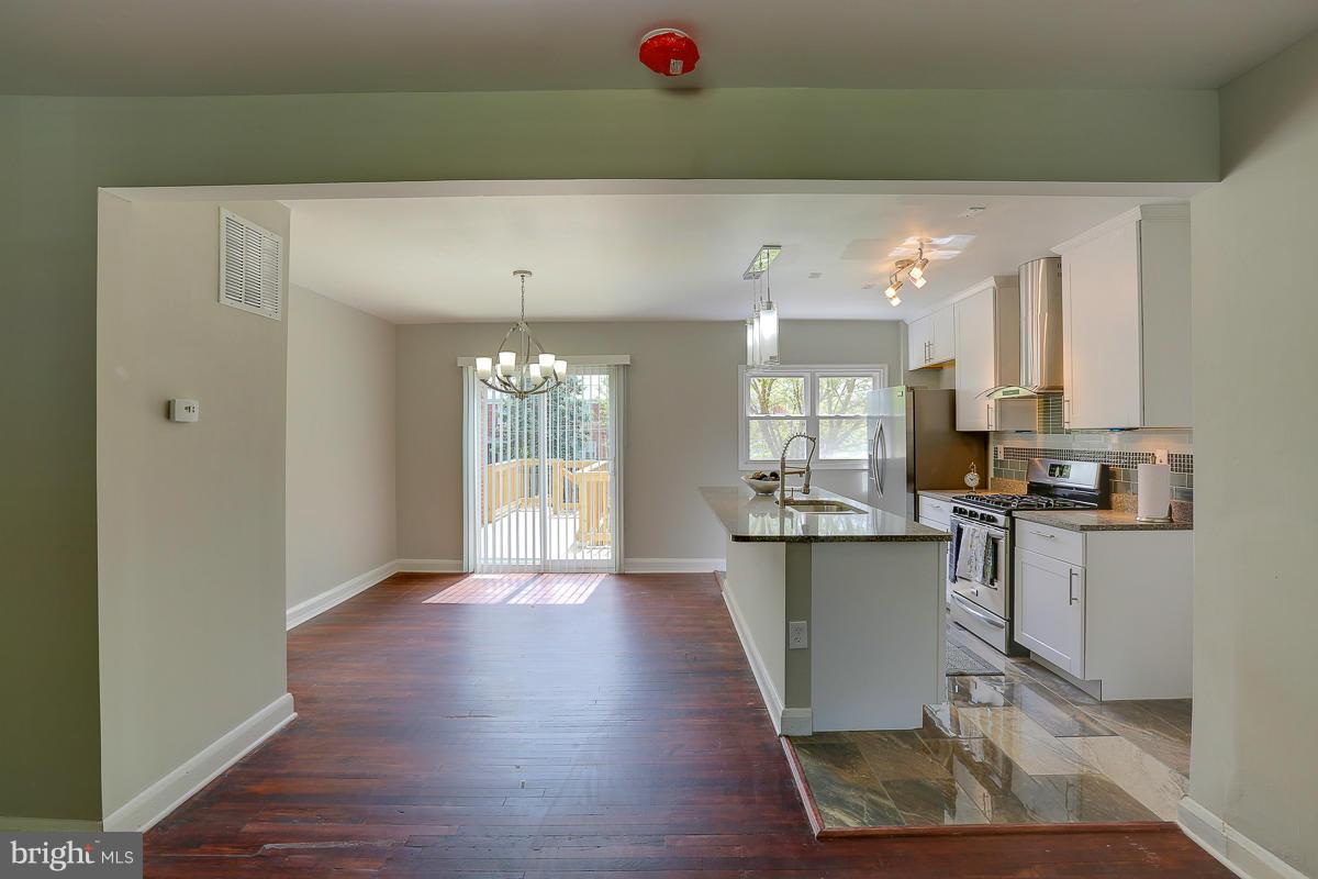6023 Falkirk Road Baltimore, MD 21239 - Photo 6 of 20 a kitchen with kitchen island granite countertop a refrigerator and a sink