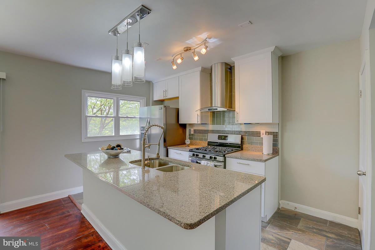 6023 Falkirk Road Baltimore, MD 21239 - Photo 8 of 20 a kitchen with stainless steel appliances granite countertop a sink a stove and a wooden floors