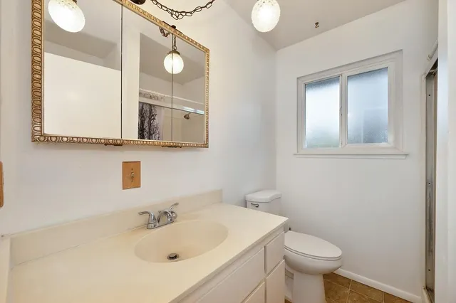 a bathroom with a sink mirror and toilet