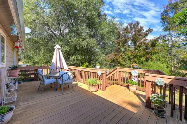 a view of deck with furniture and trees