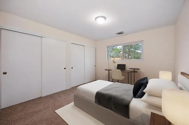 a bedroom with a bed and a window