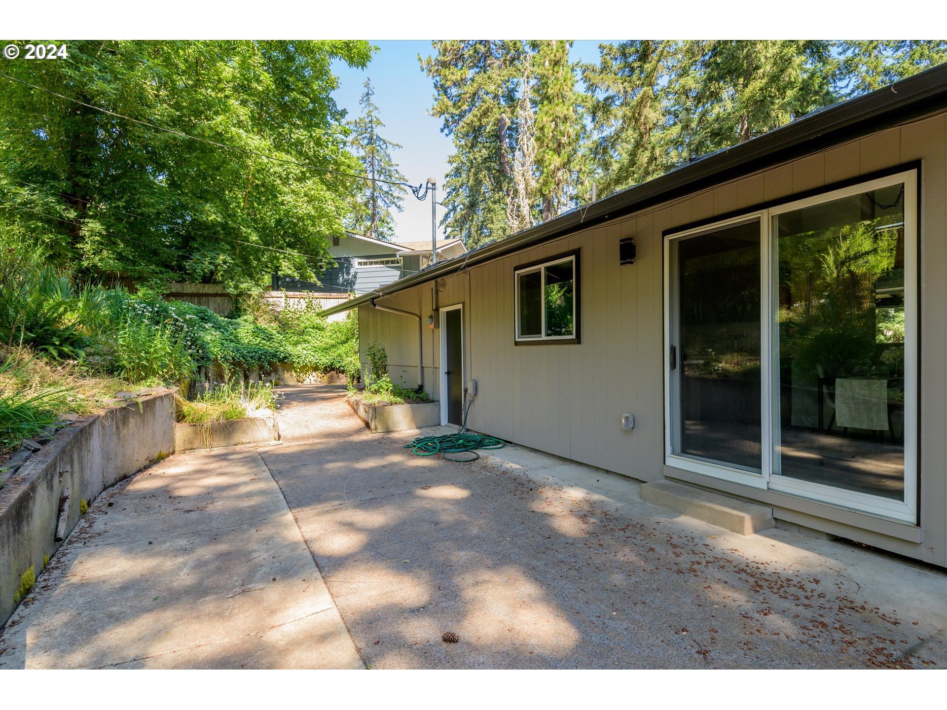 70 Coachman Drive Eugene, OR 97405 - Photo 34 of 43 a view of backyard with large trees and plants