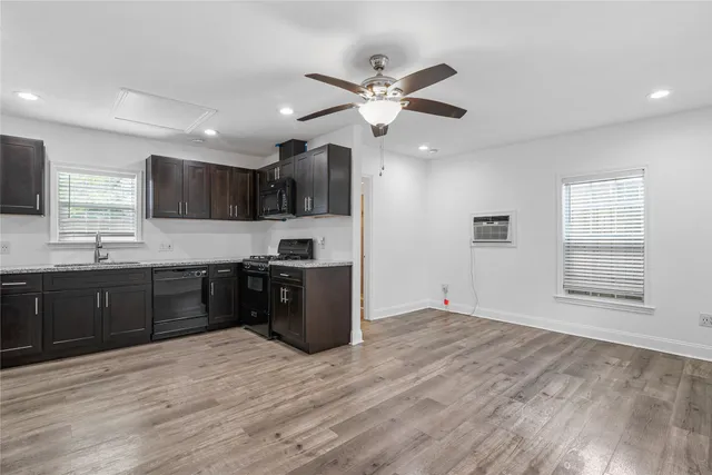 a kitchen with stainless steel appliances granite countertop a sink cabinets and wooden floor