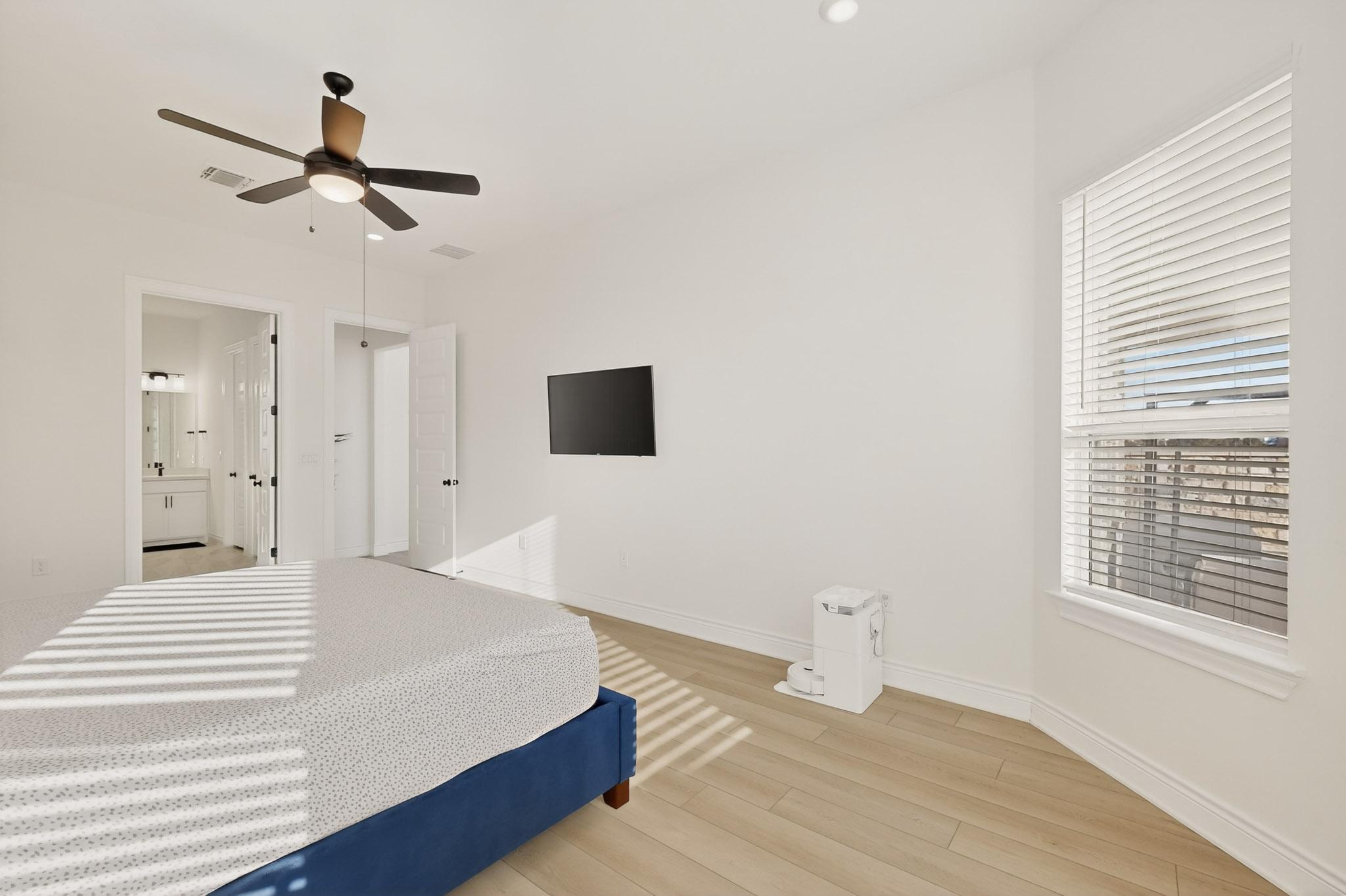 2121 Lolo Lane Leander, TX 78641 - Photo 11 of 26 Bedroom with wood finished floors, a ceiling fan, and ensuite bathroom