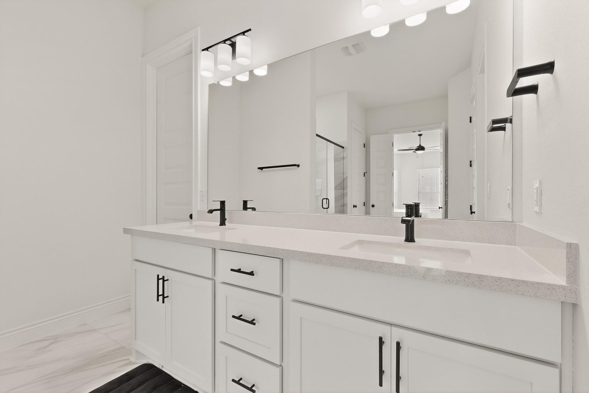 2121 Lolo Lane Leander, TX 78641 - Photo 12 of 26 Bathroom with double vanity, a stall shower, and a ceiling fan
