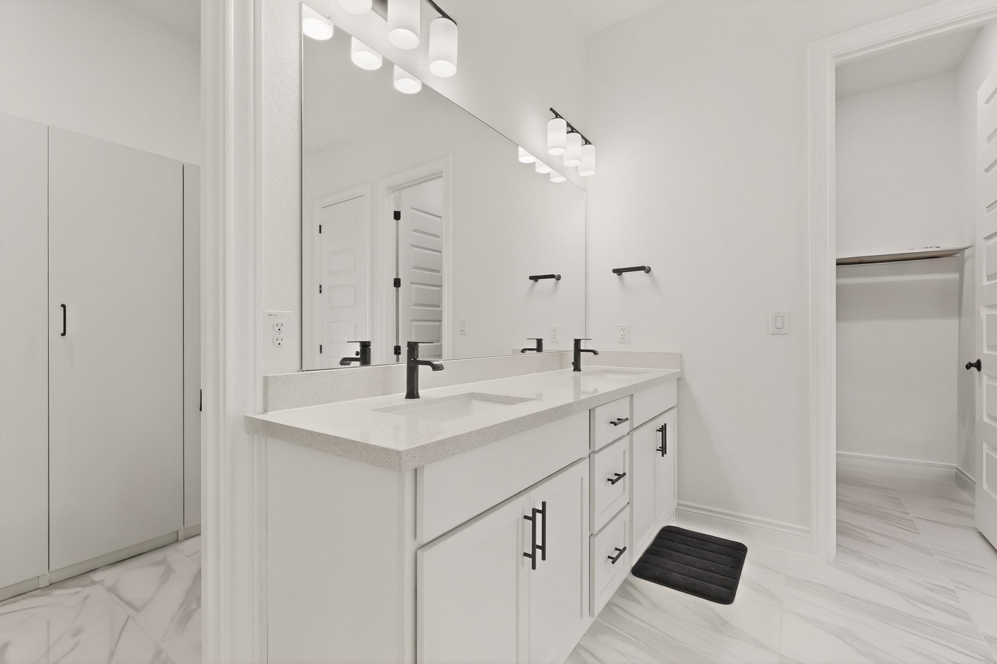 2121 Lolo Lane Leander, TX 78641 - Photo 13 of 26 Full bath with double vanity, a walk in closet, and light marble finish flooring