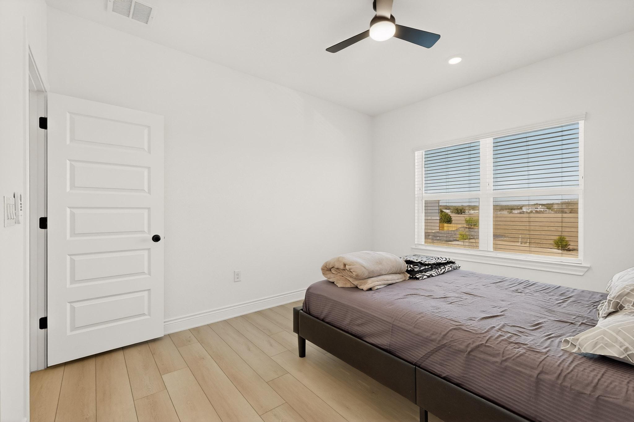 2121 Lolo Lane Leander, TX 78641 - Photo 22 of 26 Bedroom featuring ceiling fan, light wood-style flooring, and recessed lighting